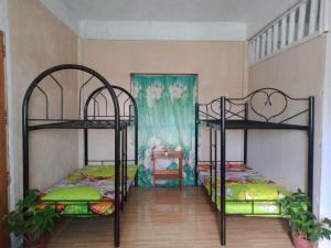 a bedroom with two bunk beds and a table at Titaays Surfers Inn in Baras
