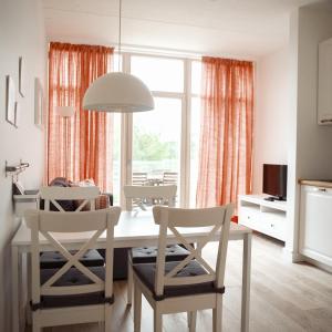 a kitchen and dining room with a table and chairs at Domi Lini in Druskininkai