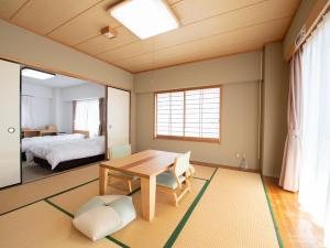 笛吹市的住宿－Chateraise Lodge Kasugai，一间带桌子的房间和一间卧室