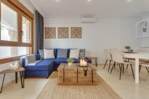 soleadore sol في أوريويلا: غرفة معيشة مع أريكة زرقاء وطاولة
