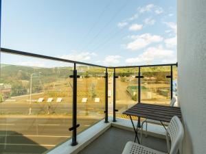 a balcony with a table and a view of a street at 25Inn Hengchun Kenting in Nanwan