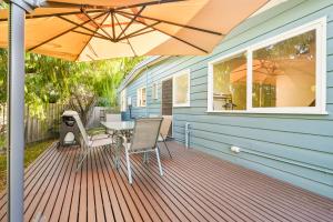 a wooden deck with an umbrella on a house at Beach Cottage. 100m to the beach 9minutes to Hot Springs. Pet Friendly in Capel Sound
