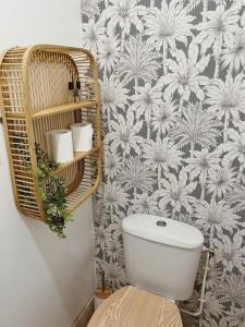 ein Badezimmer mit einem weißen WC und einer Blumentapete in der Unterkunft L'appartement du bonheur l Saint-Gilles les Bains in Grand Fond