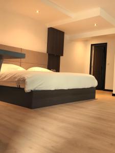 a bedroom with a large bed with white sheets at Modern'Hotel in Valenciennes