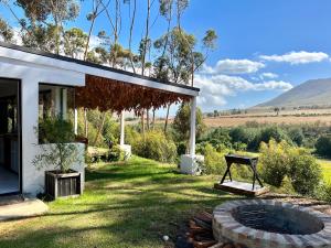 ein Haus mit einer Feuerstelle im Hof in der Unterkunft Cornellskop Country Stay in Botrivier