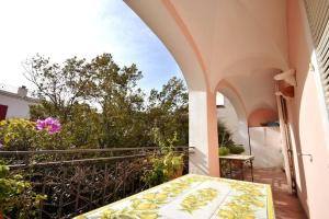 een balkon van een huis met een tafel bij CASA GADEAMUS via le botteghe 12 in Capri