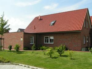 a brick house with a red roof at Ferienhaus Sabine Norddeich in Norddeich