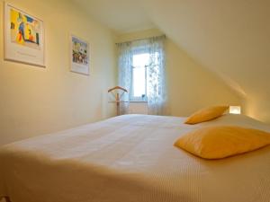 a large white bed in a room with a window at Ferienhaus Sabine Norddeich in Norddeich