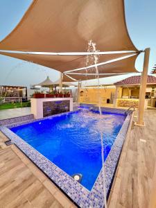 una piscina con una fuente en una casa en AlDana Resort & Hotels, en Barka