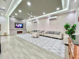 a waiting room with couches and a flat screen tv at AlDana Resort & Hotels in Barka
