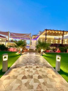 a walkway leading to a building with lights at AlDana Resort & Hotels in Barka
