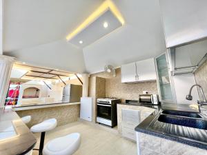 una cucina con armadi bianchi e lavandino di AlDana Resort & Hotels a Barka