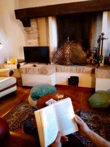a person reading a book in a living room at Villa Podere Cartaio Bio Estate Pool AirC in San Rocco a Pilli