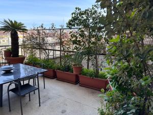 a patio with a table and a bunch of plants at house green station in Bari