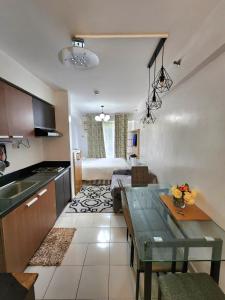a kitchen and living room with a table and a couch at NORTHPOINT CONDO Free Airport Pick Up for 3 nights stay or more in Davao City