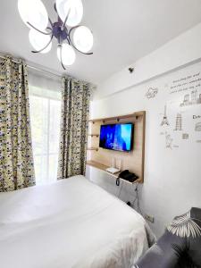 a bedroom with a bed and a flat screen tv at NORTHPOINT CONDO Free Airport Pick Up for 3 nights stay or more in Davao City