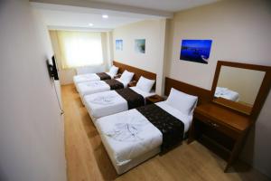 a hotel room with four beds and a mirror at Istanbul Family Apartment in Istanbul