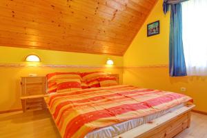 um quarto com uma cama e um tecto de madeira em Andrea Villa Hévíz I Balaton em Hévíz