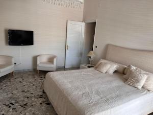 a bedroom with a bed and a chair and a television at house green station in Bari