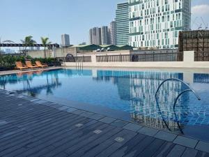 a swimming pool with chairs and buildings in the background at Manhattan Plaza Tower 1 in Manila