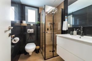 een badkamer met toilet, wastafel en douche bij Melony Apartments Yam Suf Street in Eilat