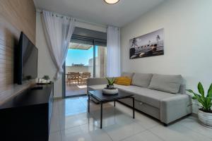 een woonkamer met een bank en een tafel bij Melony Apartments Yam Suf Street in Eilat