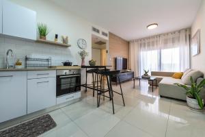 een keuken en een woonkamer met een bank bij Melony Apartments Yam Suf Street in Eilat