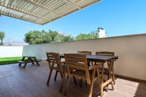 een eettafel en stoelen op een patio bij Melony Apartments Yam Suf Street in Eilat +35 foto's