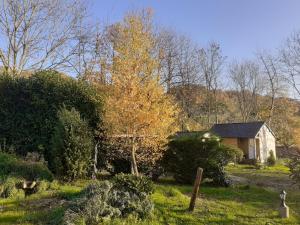una pequeña casa en un campo con árboles y arbustos en Maison d'hôtes indépendante à la campagne, en Ablon