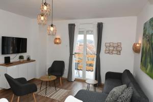 a living room with a couch and chairs and a window at Apartman Krinka in Vrnjačka Banja