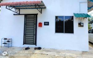 a white building with a door and a window at Myrol Homestay Kuala Ketil in Kuala Ketil