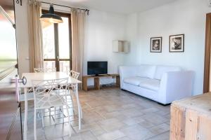 a living room with a white couch and a table at M347 - Marcelli, comodo trilocale nuovo con piscina e giardino in Santa Maria a Potenza