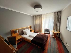 Habitación de hotel con cama y silla en Hotel Prinz, en Múnich