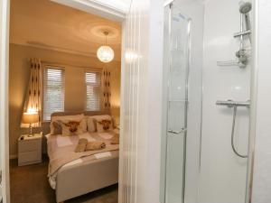 a bedroom with a bed and a glass shower at Sandown in Bowness-on-Windermere