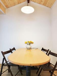 a table with two chairs and a vase with flowers on it at Sam House 2 Seochon in Seoul