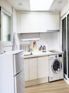 a kitchen with white cabinets and a washing machine at Sam House 2 Seochon in Seoul