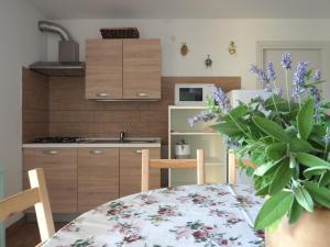uma cozinha com uma mesa de jantar e uma cozinha com um frigorífico em Casa vacanze Lepa Vida em Sistiana