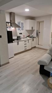 eine Küche mit weißen Schränken und eine Couch in einem Zimmer in der Unterkunft CASA HUERTA SOFIA in Murcia