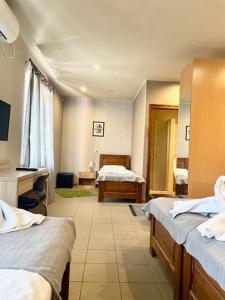 ein Hotelzimmer mit 2 Betten und einem Bad in der Unterkunft Alice Vendégház in Kalocsa