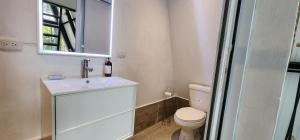 a bathroom with a toilet and a sink and a mirror at Pink house in San Lucas Tolimán