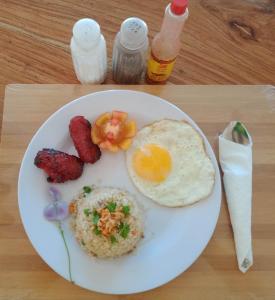 a plate of breakfast food with eggs and bacon at Titaays Surfers Inn in Baras