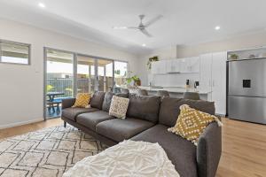 a living room with a couch and a kitchen at Dragonfly Abode, 2BR Villa in Cable Beach