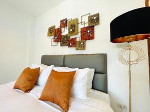 Un dormitorio con una cama con almohadas y relojes en la pared en Richmond Guesthouse Haad Rin, en Haad Rin
