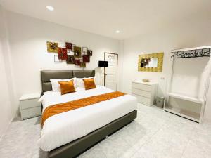 a bedroom with a large bed with orange pillows at Richmond Guesthouse Haad Rin in Haad Rin