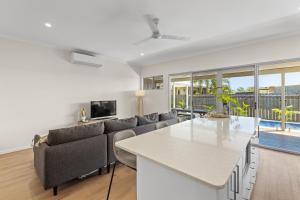 a living room with a couch and a table at Dragonfly Abode, 2BR Villa in Cable Beach