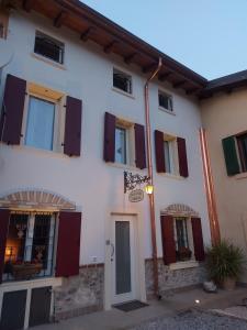 a white building with red doors and windows at B&B Corte Colli Antichi in Sona