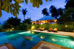 a swimming pool in front of a villa at night at Lamai Buri Resort in Lamai