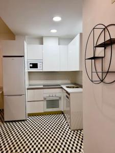 cocina con electrodomésticos blancos y suelo a cuadros en blanco y negro en RockSide Residences Suites La Línea N1, en La Línea de la Concepción