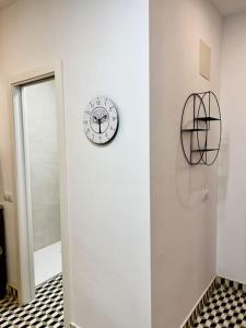 un reloj en una pared junto a un espejo en RockSide Residences Suites La Línea N1, en La Línea de la Concepción