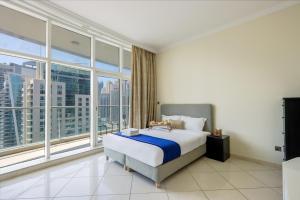 a bedroom with a large bed and large windows at Dubai Marina 3 Bedroom Suite with Full Marina View in Dubai